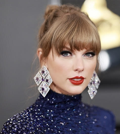 A picture of Taylor Swift - a woman with big earings, a sparkly dress, and blond hair